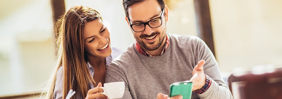 man and woman drinking coffee in their house discussing saving money and taking steps towards financing their future 