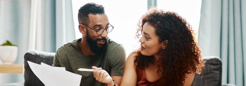 Couple looking at documents and using a debt-to-income ratio formula to determine their loan eligibility.