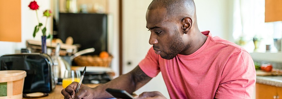 Man at table calculating and comparing different loan options