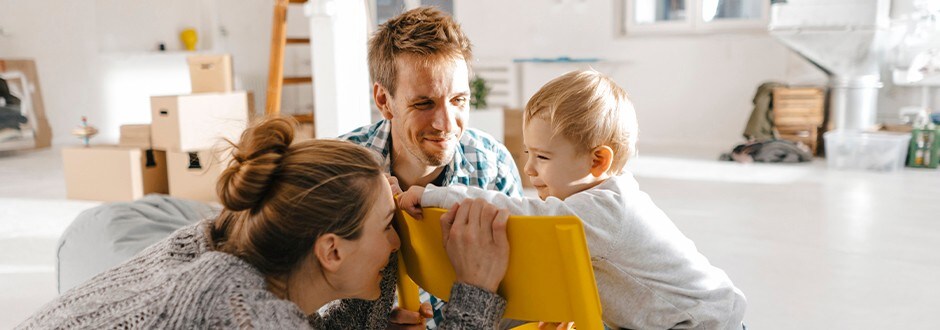 Couple playing with their young son in the play room of their house