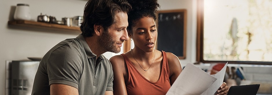 Young couple in their kitchen reading about how home equity loans work.