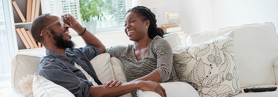 Family in living room laughing while they discuss what a second mortgage is as well as the benefits risks and other options.