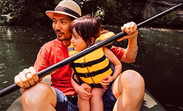 A man and a child in a canoe on a river.