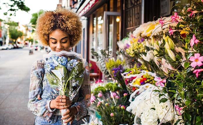 A woman looking at a bouquet of flowers.
