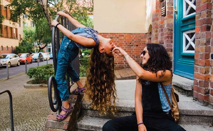 Mom and daughter play on the steps of a building.