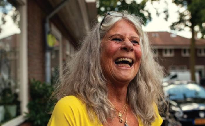 An older woman laughing in a yellow shirt. Here are some tips on how to retire successfully.