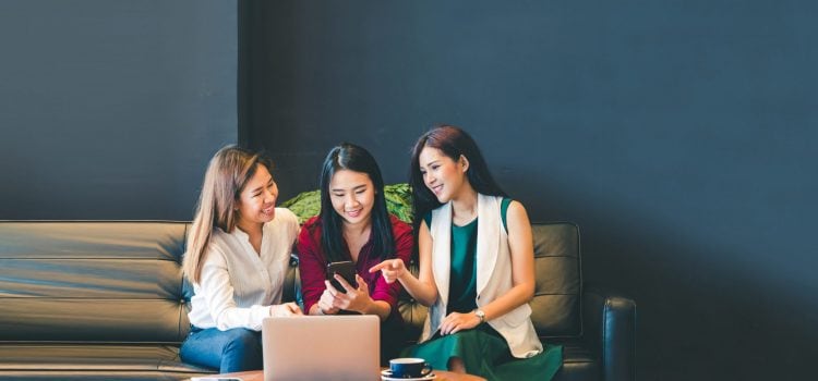 Three college students looking at a mobile phone