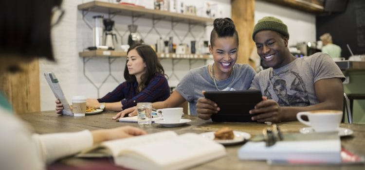 Young couple sitting at a coffee house, talking about how to financially prepare for a job transition