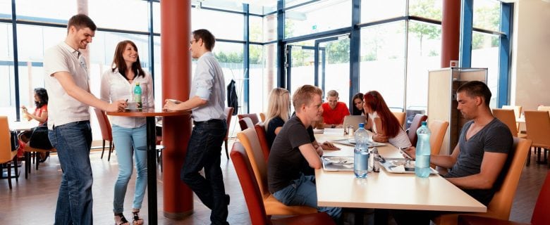 A group of college students eating at the dining hall.