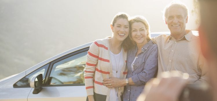 Parents and college-aged daughter smiling for a photograph