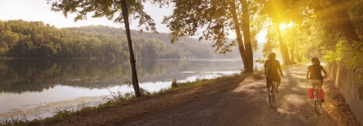 Couple riding bikes along the water