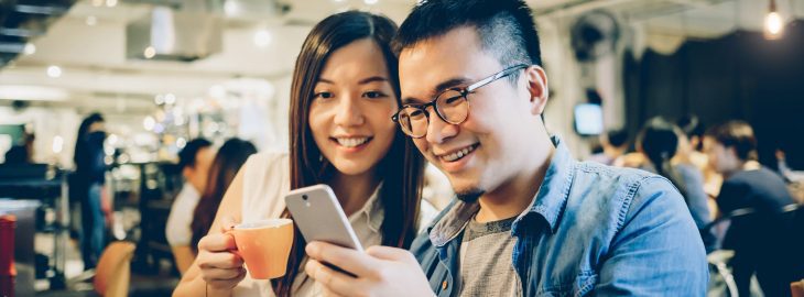 Couple looking at compounding interest calculations on a mobile phone