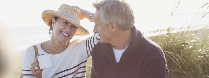 Couple on the beach, enjoying their morning coffee