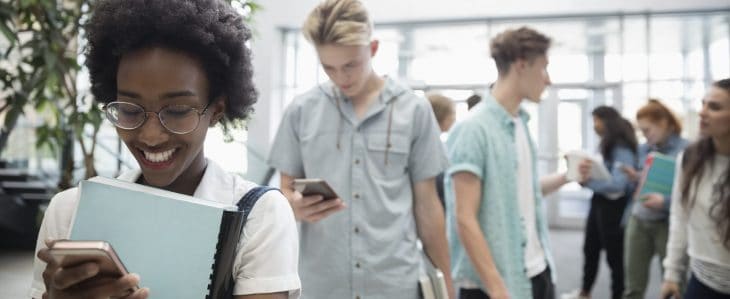 College students checking their phones between classes