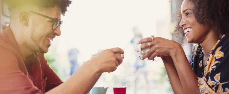 Man and woman laughing over coffee