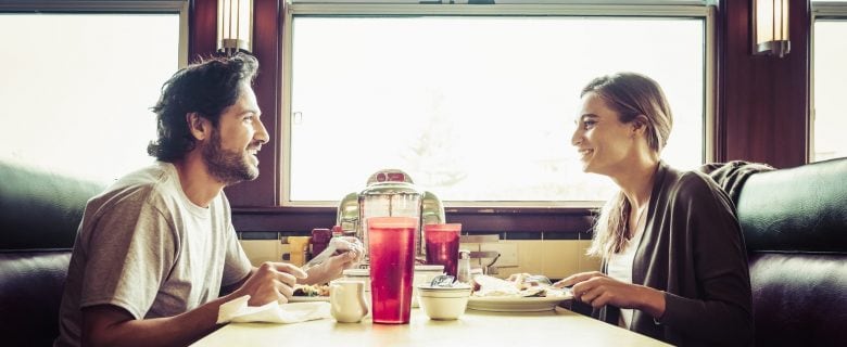 A young couple enjoying a meal together at a diner.