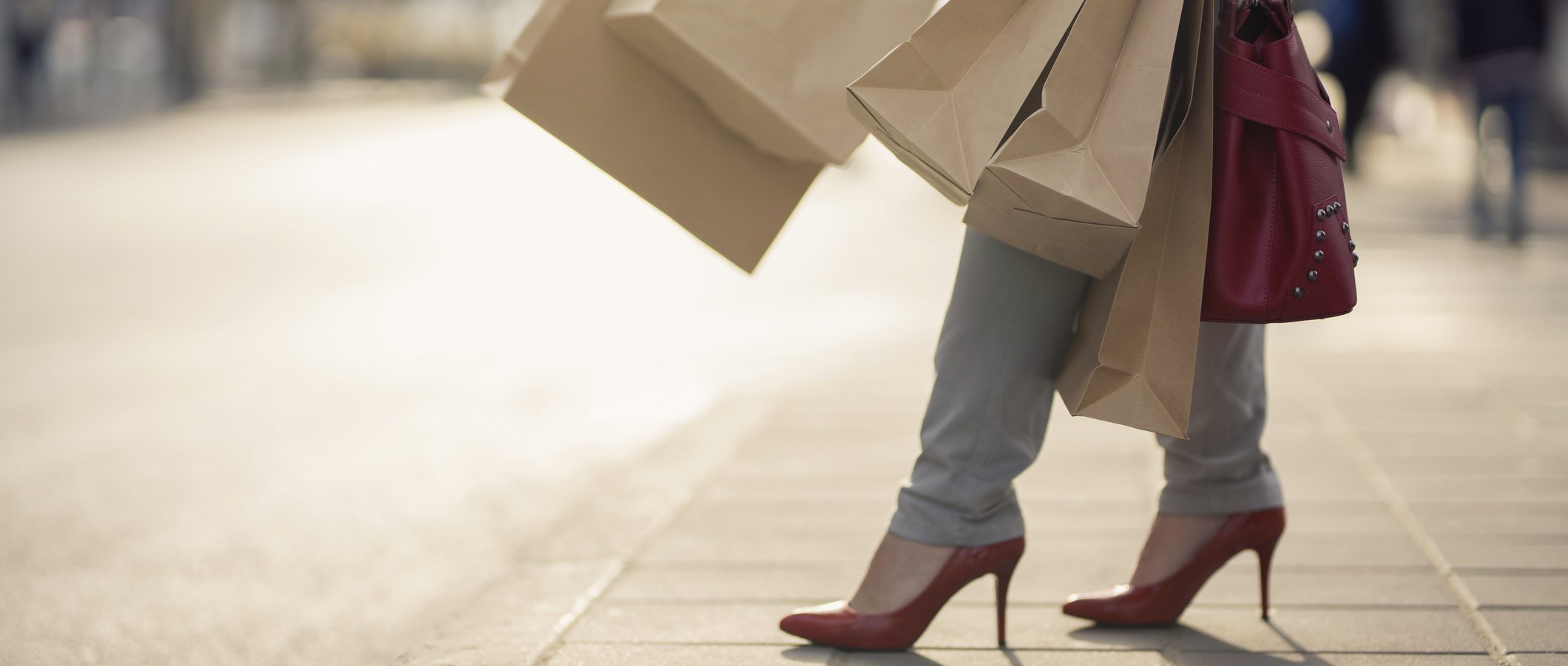A woman wearing high heels, holding several shopping bags.