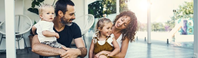 Young family sitting out on their front porch