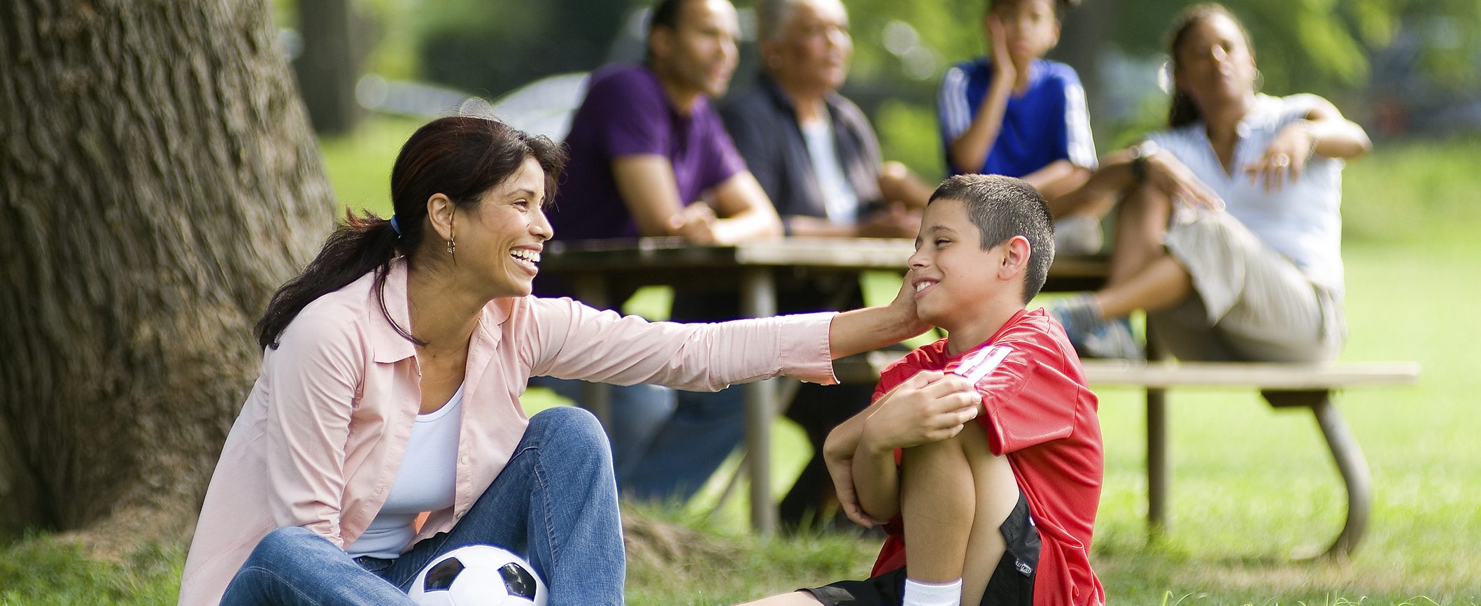 A woman and her young son share a moment together after a soccer game.