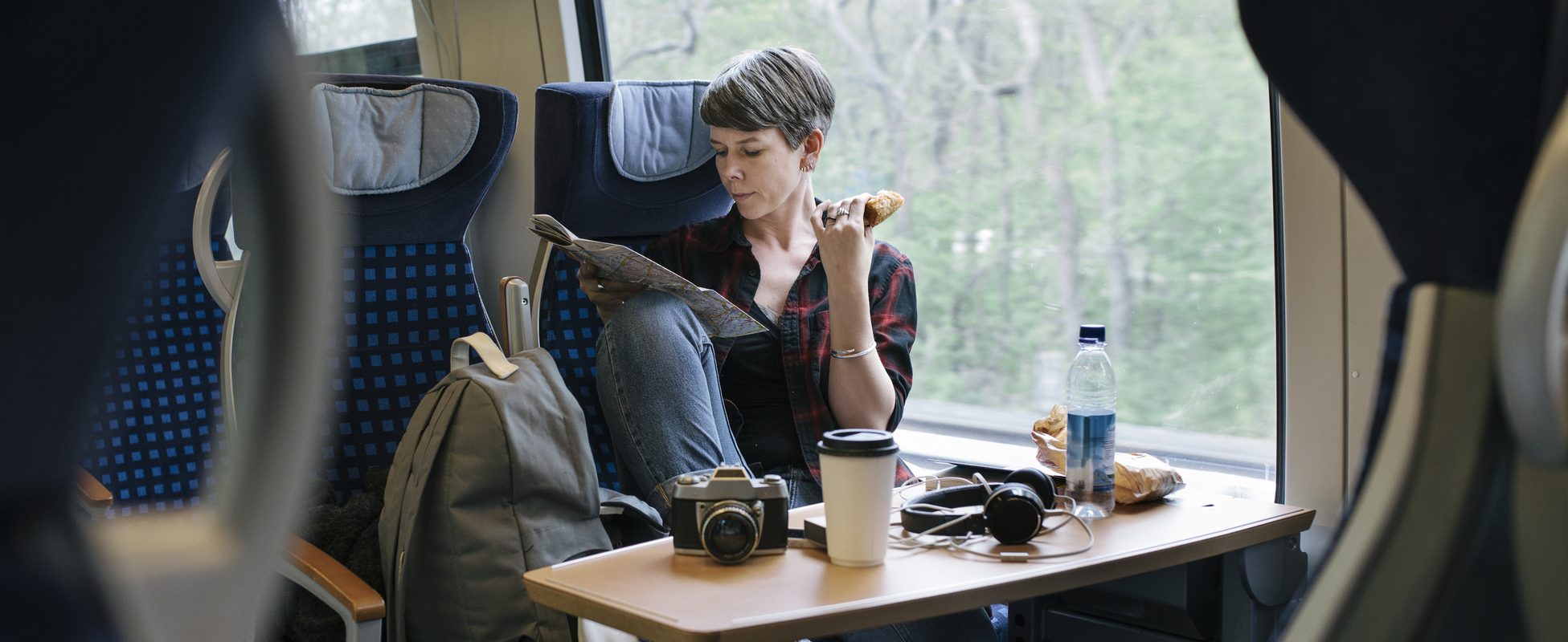 Woman travelling by train enjoys her trip while saving money