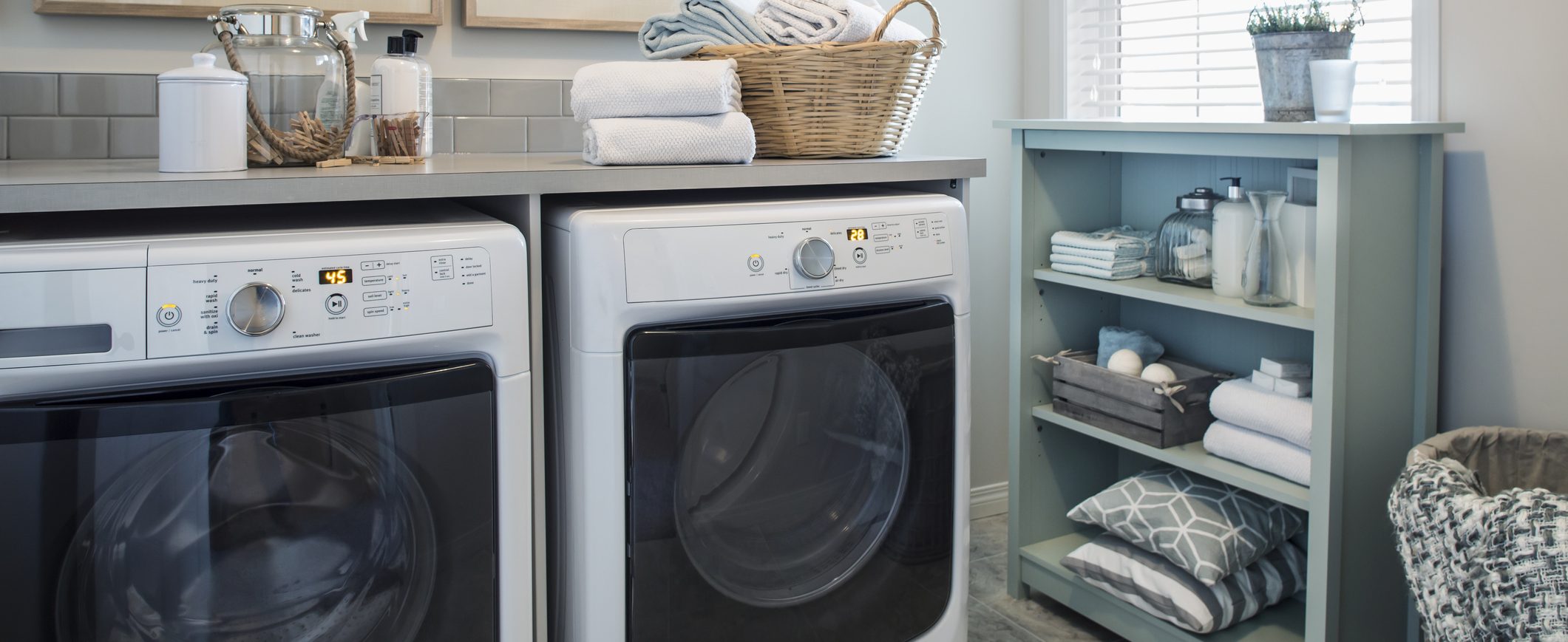 Inside of a laundry room, showing the washer and dryer next to each other.