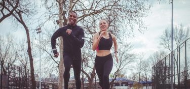 A man and a woman jog outside.