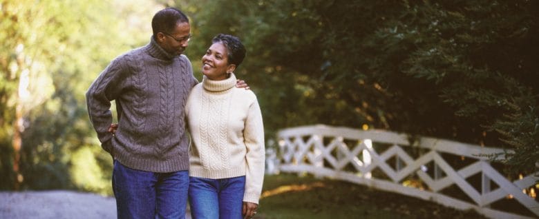 An older couple enjoys a walk together around the neighborhood.