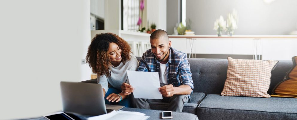 Wife and husband review their tax papers on the couch together.