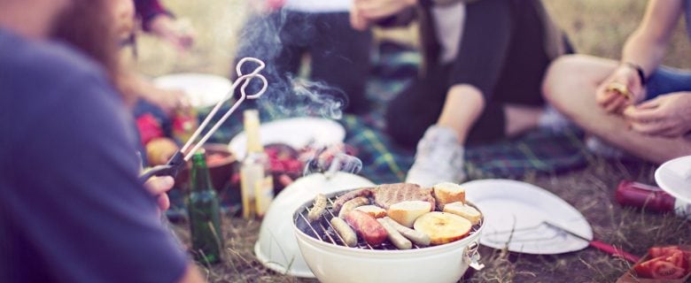 Festival-goers cook their meal on a small hibachi grill.