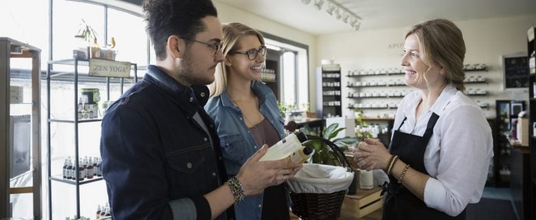 Customers at a boutique shop talk with a store clerk.