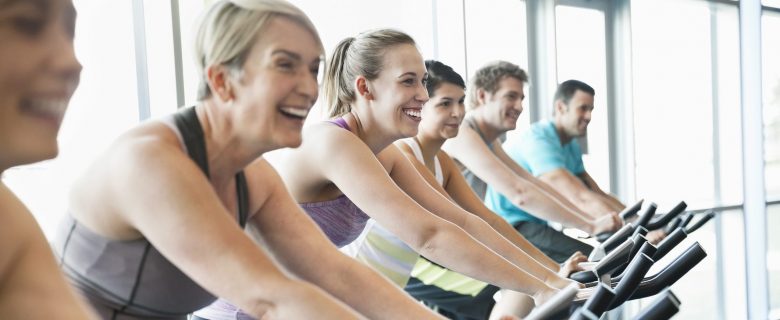 A group of people at a spin class on stationary bikes.