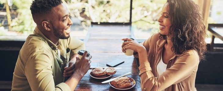 A man and a woman enjoy breakfast together at a coffee shop.