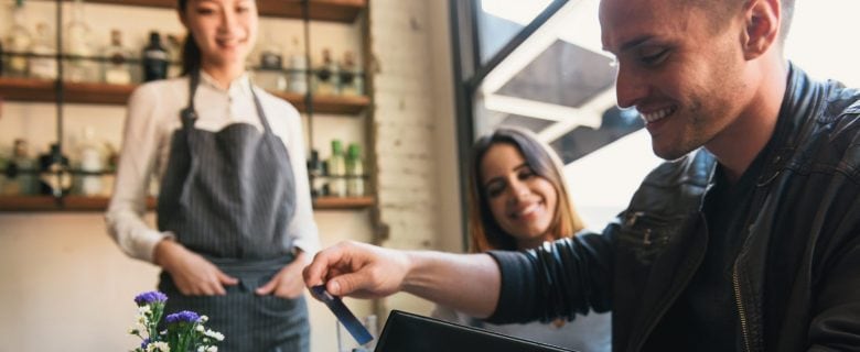 A couple, out on a date at a restaurant, pays their check.