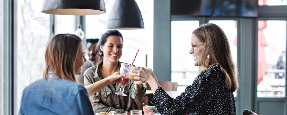 Three women toasting with various juice drinks.