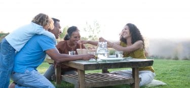 Grandparents share a meal with their daughter and grandchild.