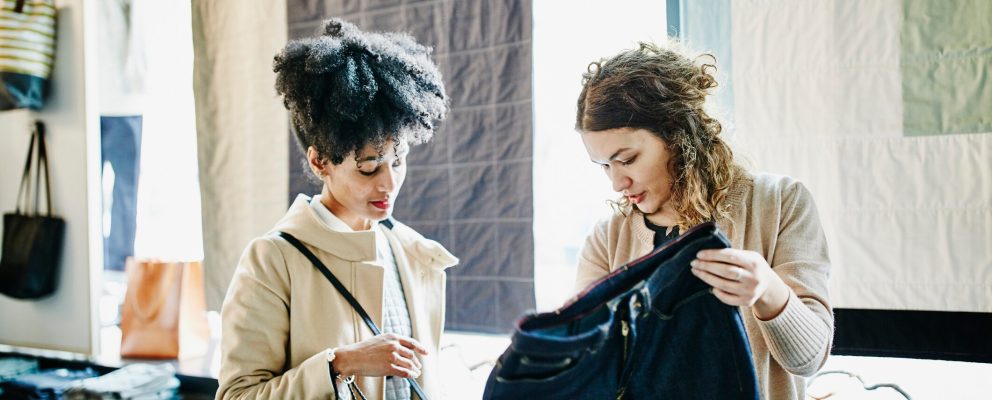 Two women look at a pair of pants.