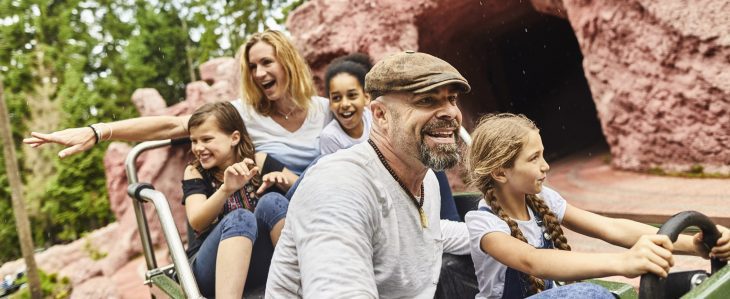 A family rides a roller coaster together. 