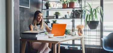 Woman sitting at a desk working on a laptop.