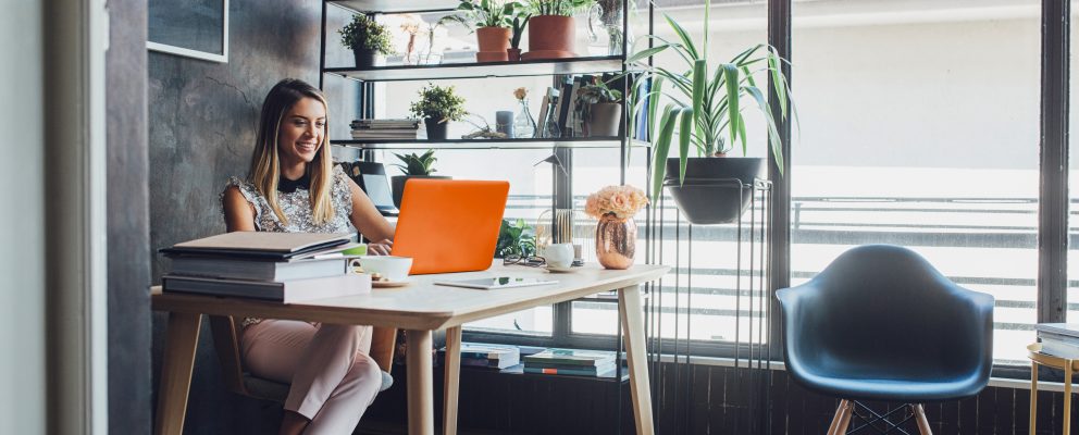 Woman sitting at a desk working on a laptop.