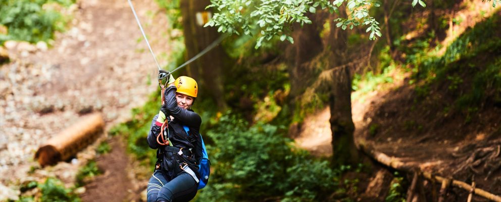A woman rides a zip line.