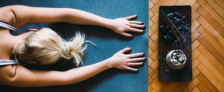 A woman does yoga while burning incense.