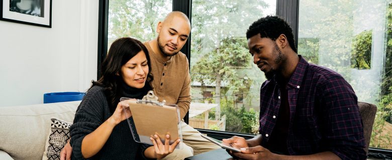 A woman and man review a document with their financial advisor.