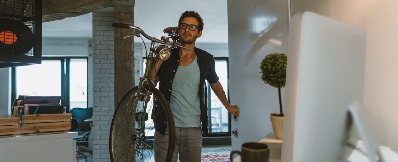 A man carries his bike into his apartment.