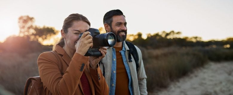 A couple, traveling together, snaps photographs.