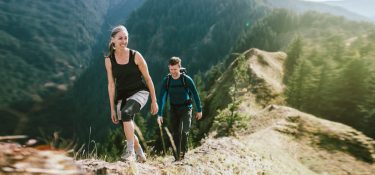 A man and a woman hike on a mountain.