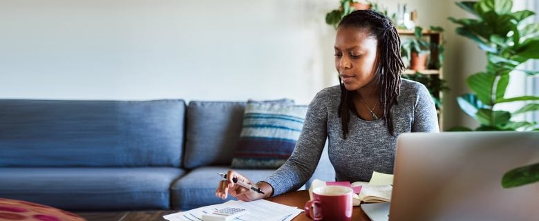 A woman in her office, working out some calculations.