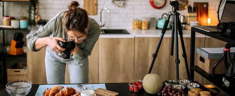 A blogger photographs a table of food.