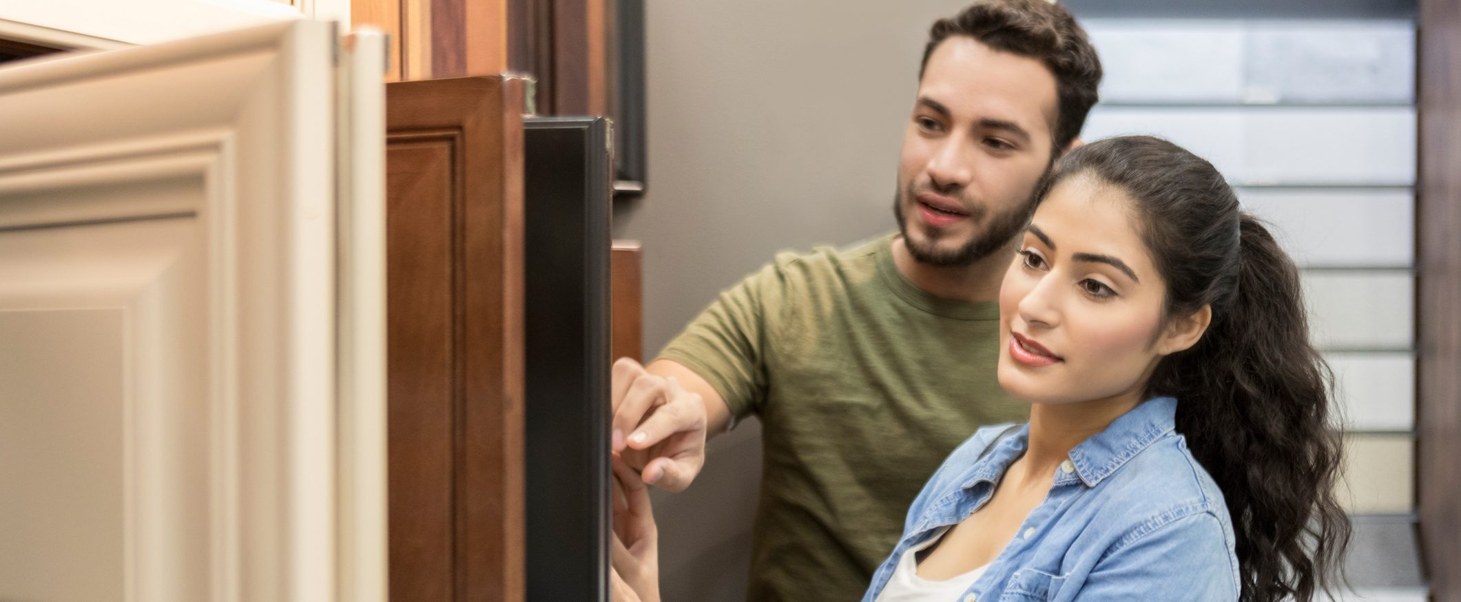 Two people browse cabinet doors in an interior design store.