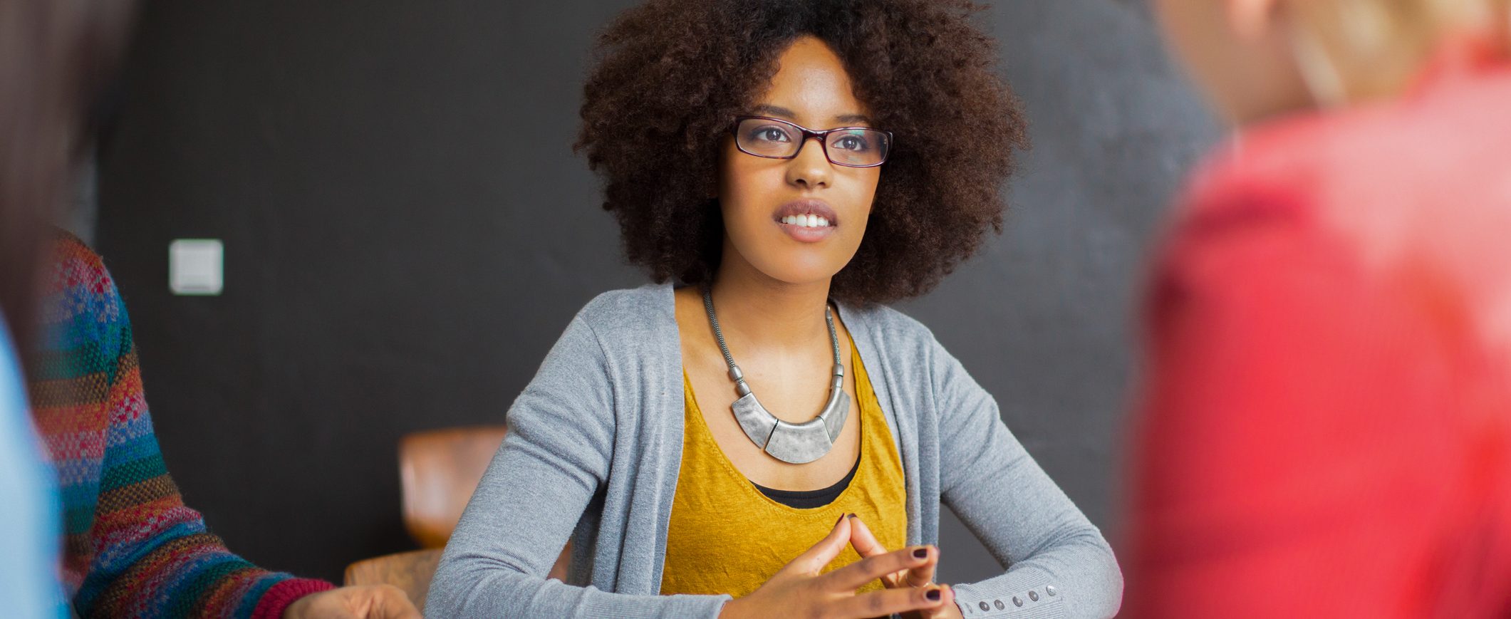 A woman sits in a meeting listening.