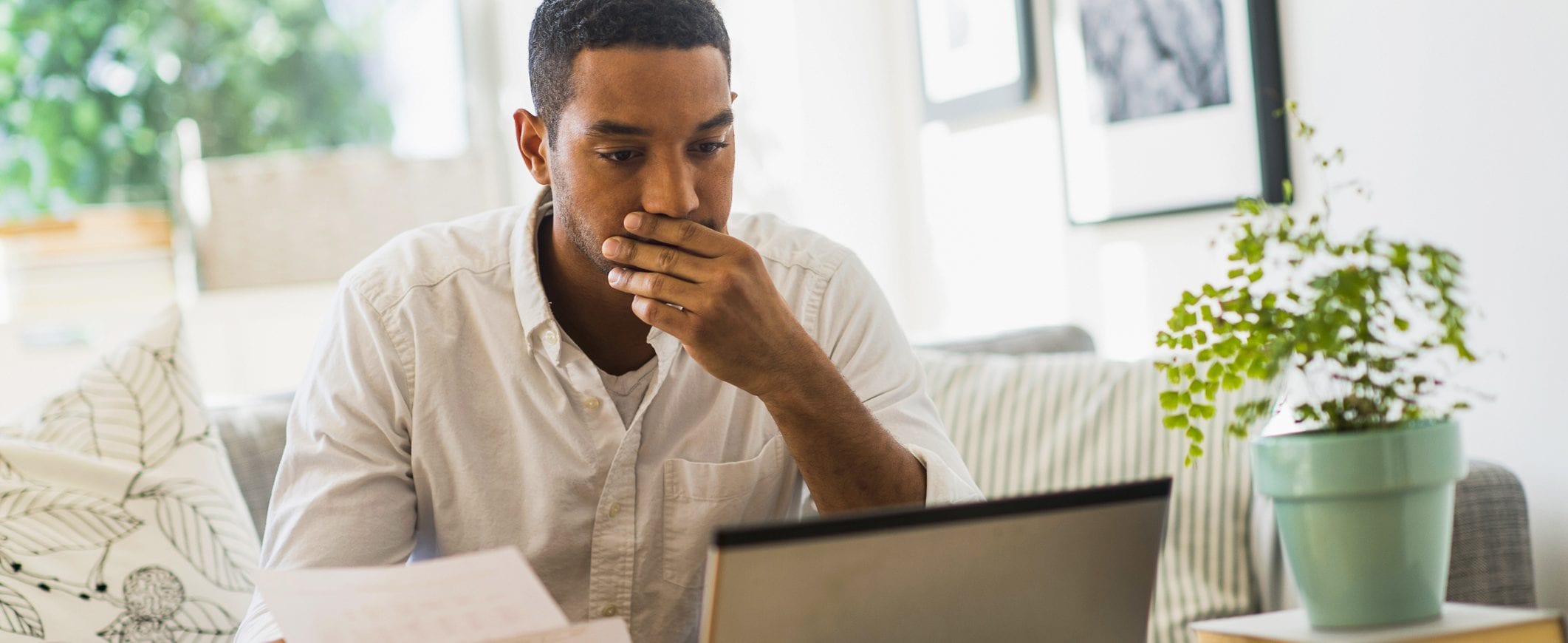 A man reads a laptop.